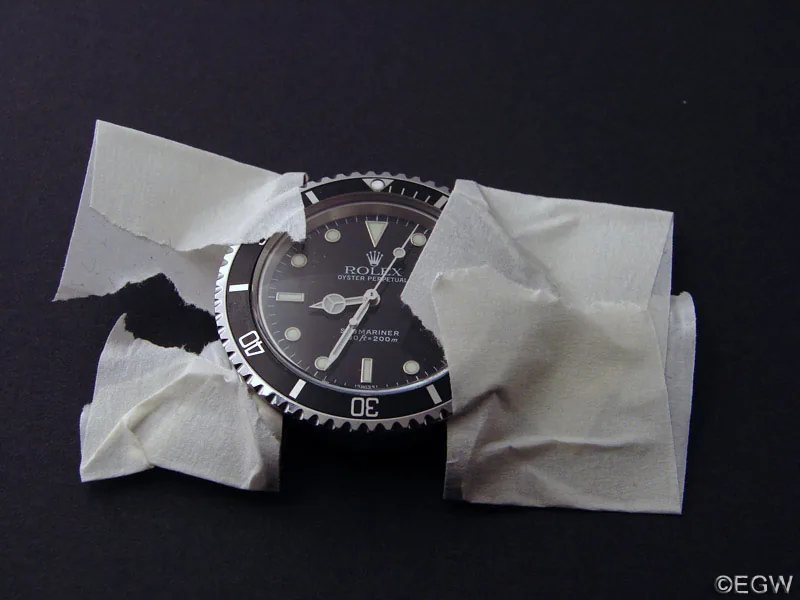 Rolex Submariner mit abgeklebten Hörnern auf dunklem Untergrund