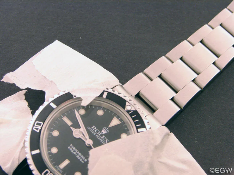 Rolex Submariner mit montiertem Stahlband auf einer Seite, die Hörner sind noch abgeklebt