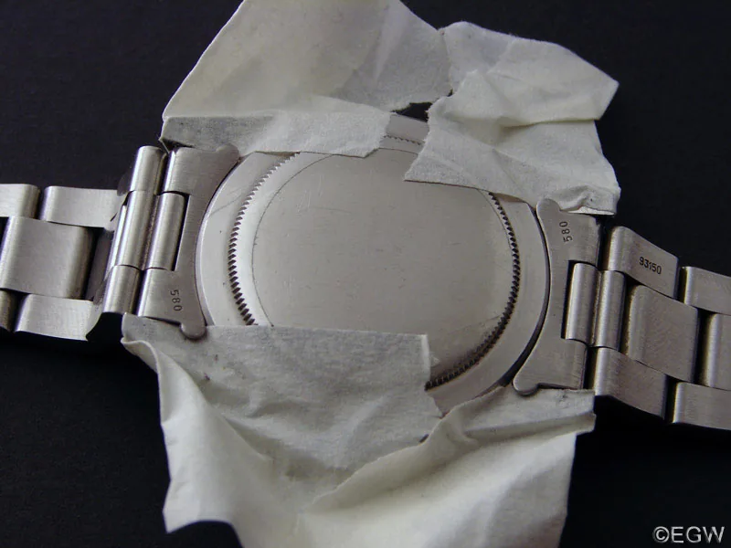Gehäuseboden einer Rolex mit beidseitig montiertem Stahlband und abgeklebten Hörnern