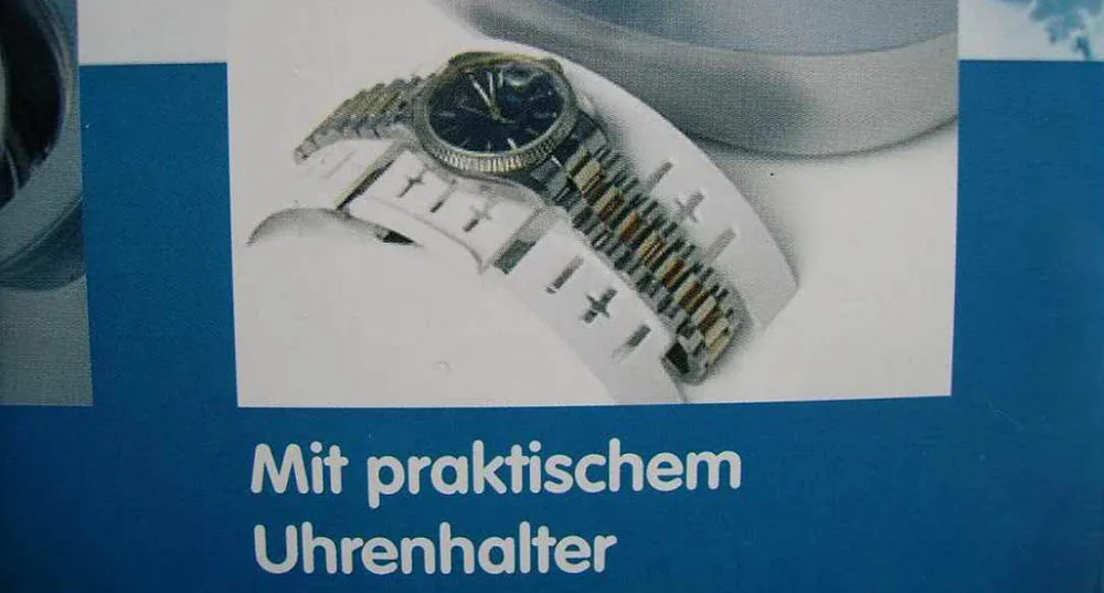 Brochure photo of an ultrasonic cleaner with a plastic watch holder, with a watch on its bracelet lying in it