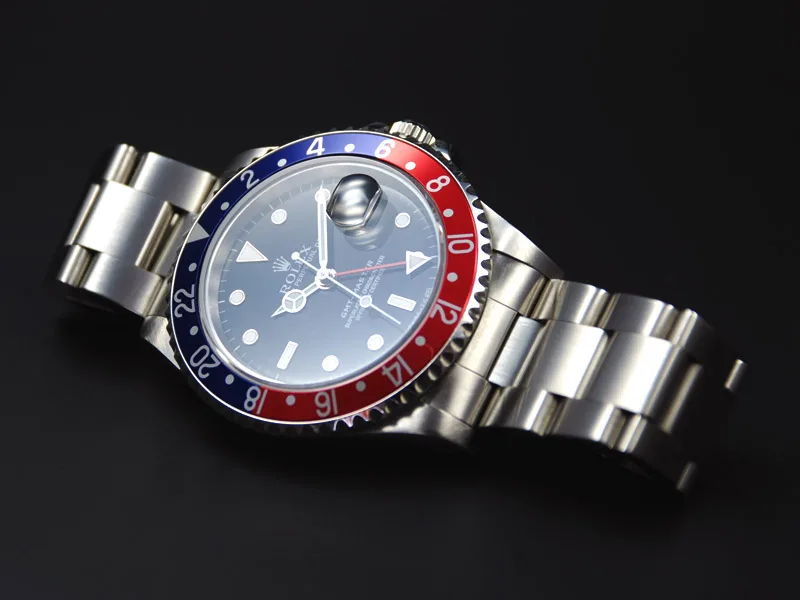 Rolex GMT-Master 16700 mit rot-blauer Lünette vor schwarzem Hintergrund