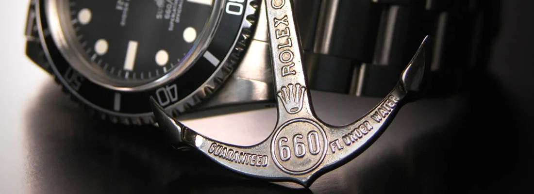 Rolex anchor in front of a dive watch with rotating bezel