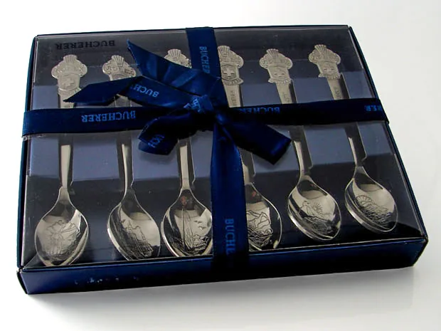 Six Rolex spoons in a clear gift box with a blue Bucherer ribbon